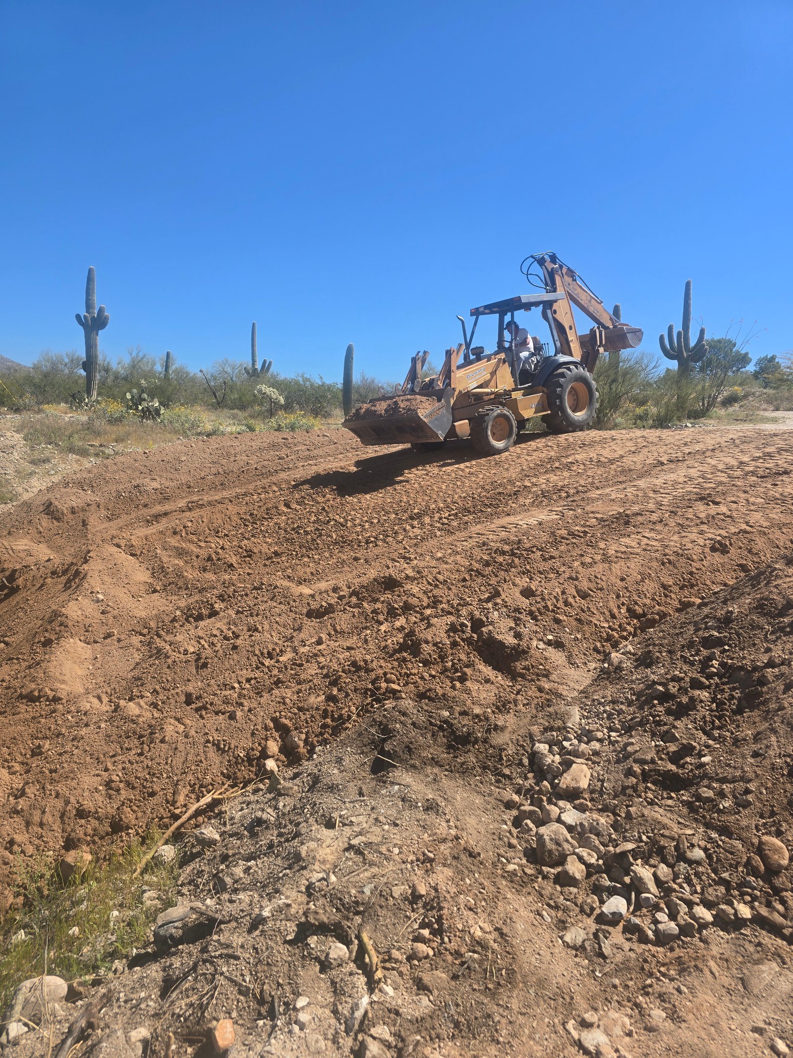 Backhoe building driveway with 99 loads of dirt